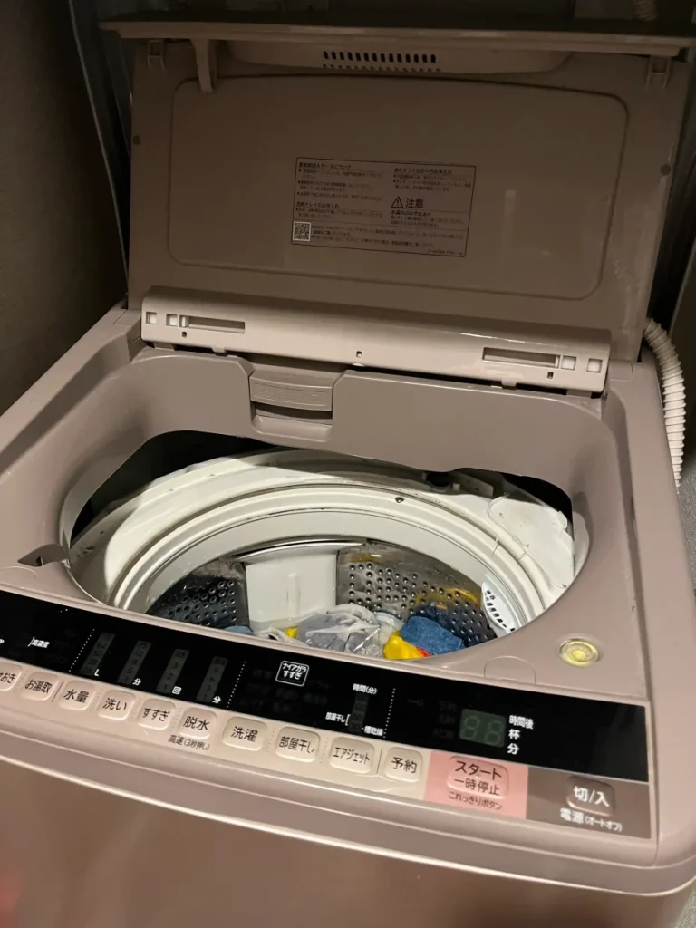 洗濯機のフタを開けて、お湯と洗剤でつけ置きしている様子