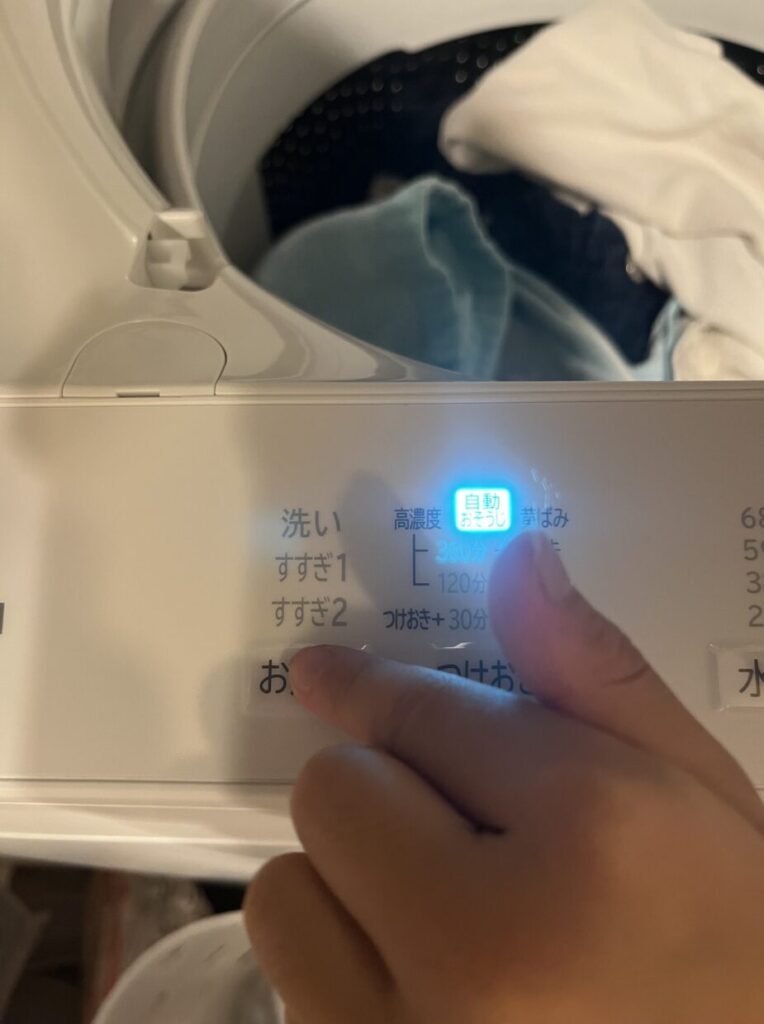 日立ビートウォッシュの操作パネルで自動おそうじ機能を設定している様子